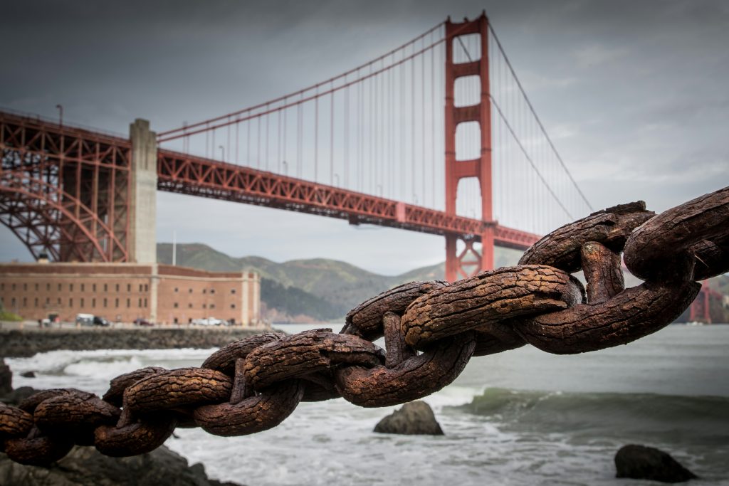 Golden Gate Bridge overlaid with a symbolic chain, representing American cultural influence and the global spread of Americamaxxing.