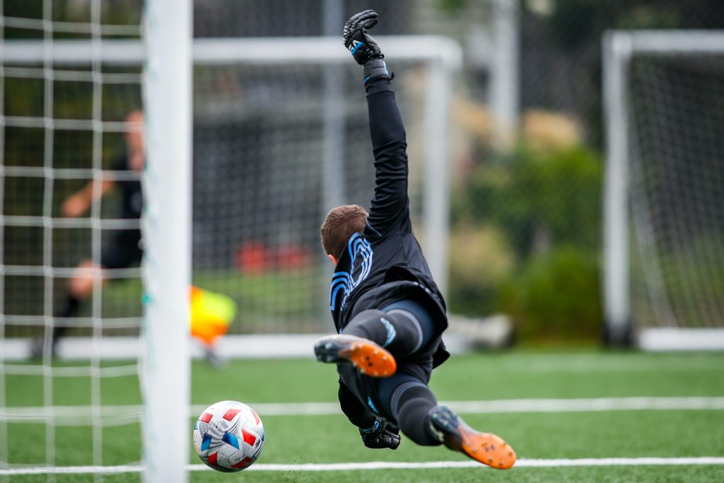 Goalkeeper diving, representing Mark Schwarzer’s football career with Leicester City and Chelsea, and the idea of a lucky charm.