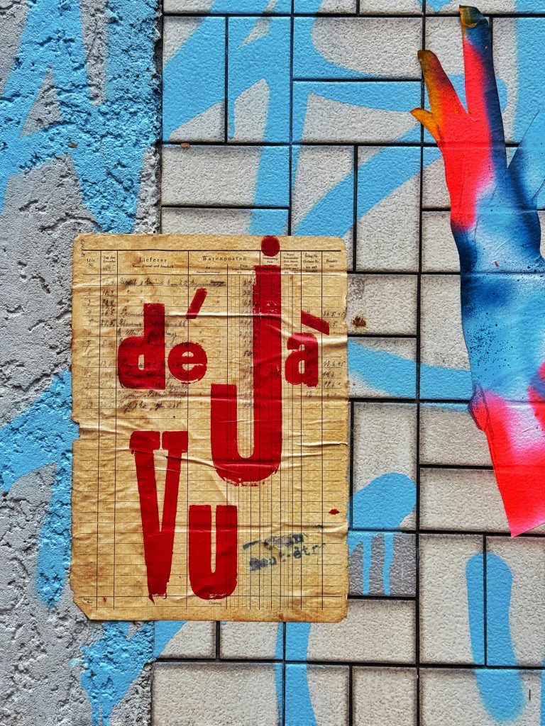 Wall poster displaying the phrase “déjà vu”, representing the complexities of English language editing and grammar.
